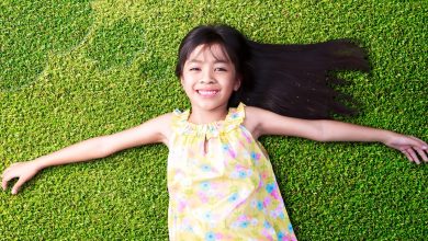 a smiling girl lying down on the grass