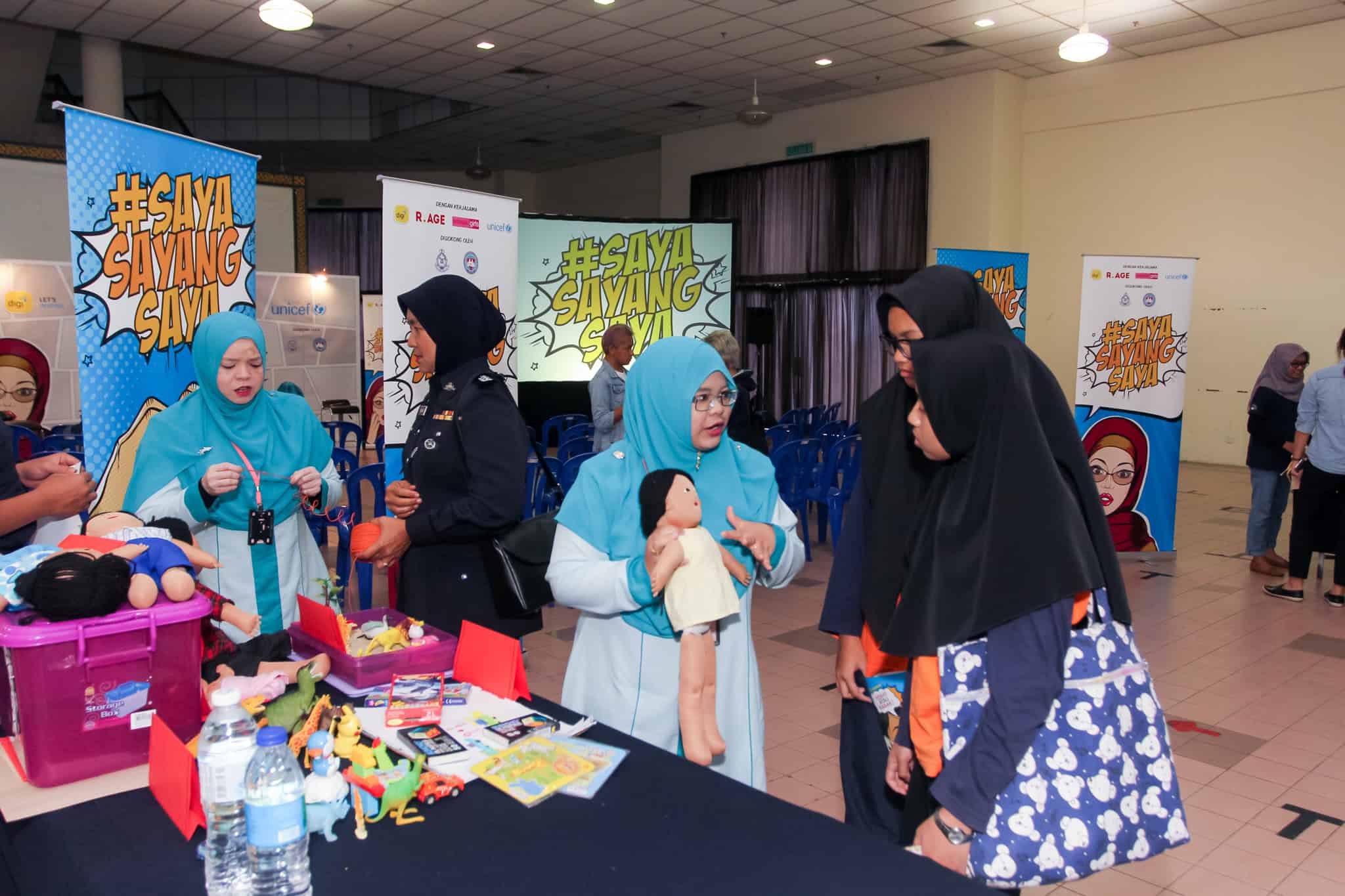 a NGO worker does a demonstration for two students on reproductive health and rights..