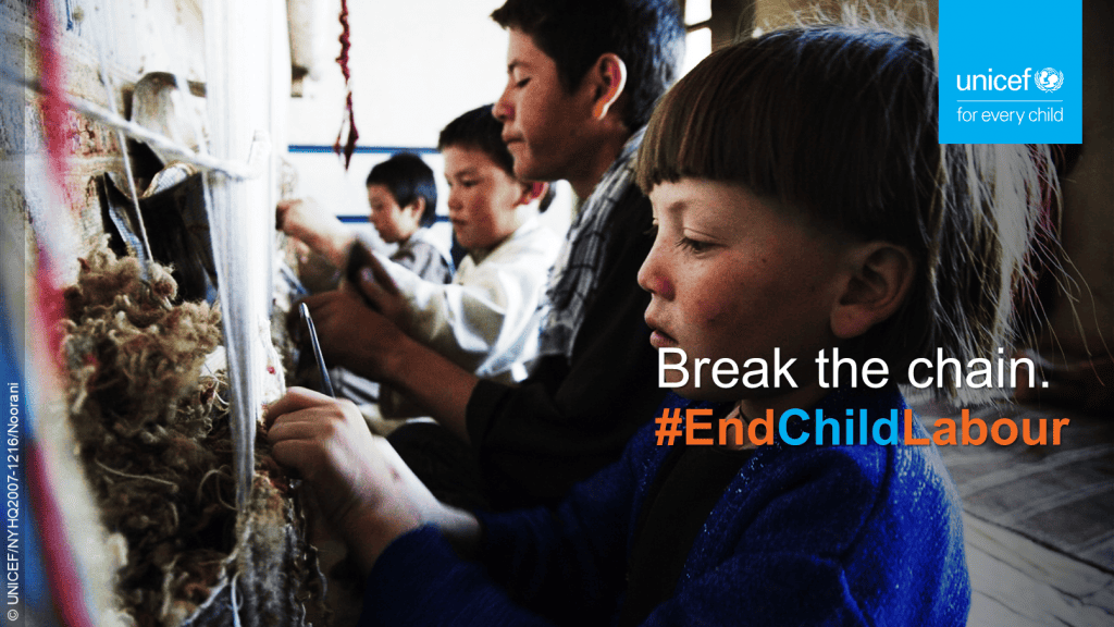 Young boys weave carpets in a factory