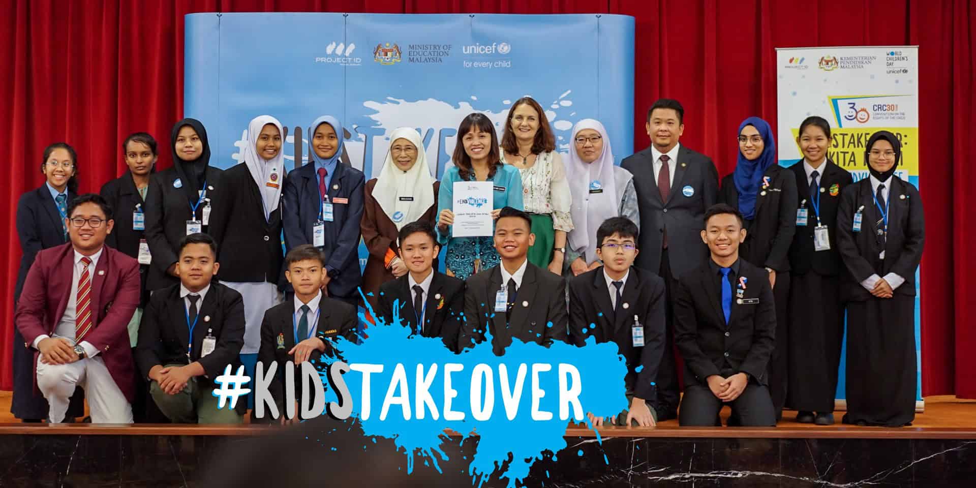 a group of students on stage at the parliament Malaysia. With them are the Deputy Prime Minister of Malaysia and the Deputy Minister of Education.