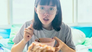 A girl eats from a bowl.