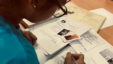A teenage girl studying. Two photos of her parents lie on top of her books.